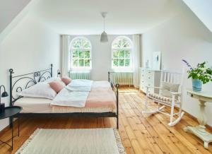 a bedroom with a bed and a desk and two windows at Artist's Studio House In Aukrug Nature Park in Meezen