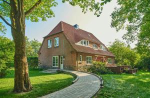 a brick house with a tree and a brick walkway at Artist's Studio House In Aukrug Nature Park in Meezen