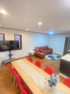 a room with a table and chairs and a couch at raikoエレベーター付き大人数向け一棟貸切宿 in Nishi-biwajima