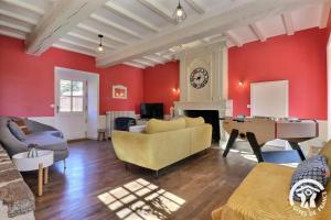 una sala de estar con paredes rojas y un piano de cola. en Quinfromel, en Clayes