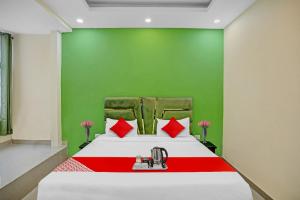 a bedroom with a bed with red and green walls at Hotel O Sunshine in Kalkaji Devi