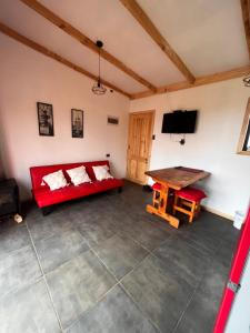 un salon avec un canapé rouge et une table dans l'établissement Cabaña arriendos Salome, à Valdivia