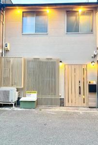 un edificio con una recinzione e una panchina di fronte ad esso di 大阪新今宫三层别墅四房一厅 a Wada