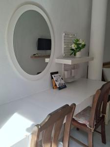 a white table with two chairs and a mirror at Suwita House in Nai Yang Beach