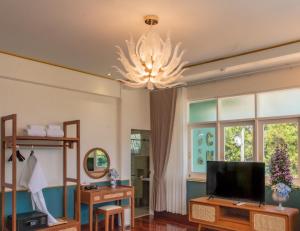 Ban Yang Pa KhaにあるChez Nij Ryokan Onsen Chiang Maiのリビングルーム(テレビ、シャンデリア付)
