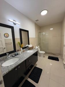 a bathroom with two sinks and a toilet at Oasis at the Towers Classy 1 bdroom in Kingston