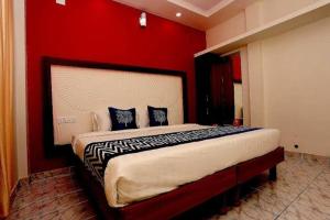 a bedroom with a large bed with a red wall at Premium Villas and Appartments thekady in Thekkady