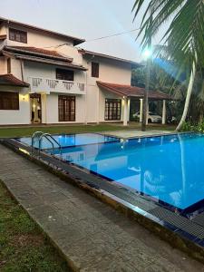a large blue swimming pool in front of a house at Larala Villa with private pool in Mawadawila +4 photos