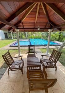 a group of chairs under a pavilion with a pool at Larala Villa with private pool in Mawadawila