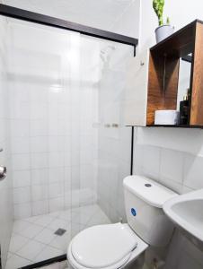 a white bathroom with a toilet and a sink at Casa Eclat in Medellín +17 photos