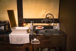 a kitchen counter with a sink and a sink at A 270-year-old soy sauce maker and a 100-year-old house collaborate to create Kamebishi-tei in Higashikagawa