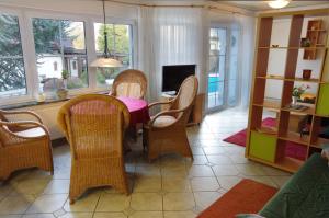 ein Esszimmer mit einem Tisch, Stühlen und Fenstern in der Unterkunft Gästehaus Gaens - Ferienhaus in Schirgiswalde