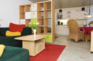 a living room with a couch and a table with flowers at Gästehaus Gaens - Ferienhaus in Schirgiswalde