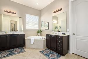 La salle de bains est pourvue d'une baignoire, de 2 lavabos, d'une baignoire et d'un miroir. dans l'établissement Luxurious villa with pool and spa, à Liberty