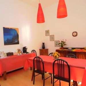 a dining room with two red tables and chairs at B&B Arabesque in Venice