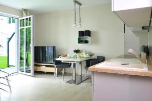 eine Küche mit einem Tisch und Stühlen sowie eine Küche mit einem Esszimmer in der Unterkunft Linden Palais Heiligendamm Apartments in Heiligendamm