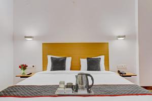 a hotel room with a bed with a tea kettle on it at Townhouse S R NAGAR in Ameerpet +41 photos