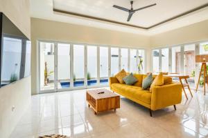 a living room with a yellow couch and a table at Aquene 2 BR Private Pool Villa ZN277 in Pererenan