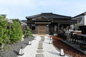 an asian house with a garden with a stone path at 陽和リトリート in Tateyama
