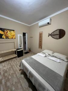 a bedroom with a bed and a fish on the wall at Jericoacoara Suítes "Zona do Kite" in Jericoacoara