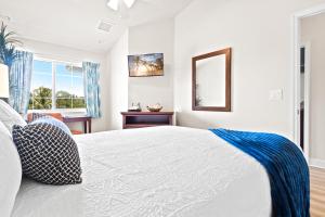 a white bedroom with a bed and a mirror at Cape Crossing 106 in Merritt Island +41 photos