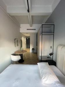 sypialnia z białym łóżkiem i stołem w obiekcie One Thibault Hotel - Cape Town City Centre w Kapsztadzie
