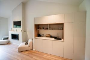 a kitchen with white cabinets and a chair in a room at Redwood Park - Luxury Off Grid Accommodation in Wollombi