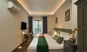 a hotel room with two beds and a window at The Passion Hotel Airport in Ho Chi Minh City