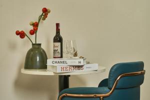 a shelf with a bottle of wine and a blue chair at The Passion Hotel Airport in Ho Chi Minh City