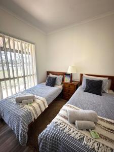 une chambre avec deux lits et une fenêtre dans l'établissement Willa Villa Bush Retreat - Gol Gol, à Gol Gol