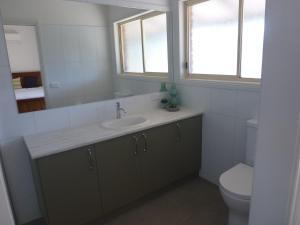 une salle de bain avec un lavabo, des toilettes et un miroir dans l'établissement Willa Villa Bush Retreat - Gol Gol, à Gol Gol 77 autres photos