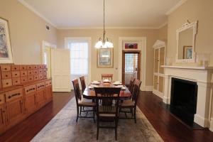 a dining room with a table and chairs and a fireplace at Oglethorpe Manor Main House in Savannah