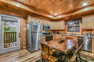 una cocina con una mesa y un refrigerador en The Smoky Pines cabin, en Waldens Creek