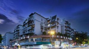 ein großes weißes Gebäude in der Nacht mit einer Straße in der Unterkunft 7 Days Inn Ya'an Langqiao Pedestrian Street Center in Ya'an