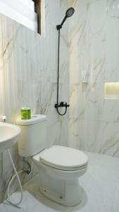 a white bathroom with a toilet and a sink at Villa Dalia Puncak Nc3-31 in Cikundul +31 photos