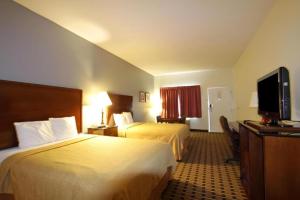 a hotel room with two beds and a flat screen tv at Americas Best Value Inn Kinston in Kinston