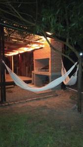 a hammock in front of a house at night at Tu lugar de relax a 2 cuadras de la playa Se reserva con seña in Guazuvira