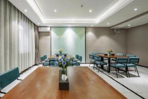 Una sala de conferencias con una mesa y sillas y una pantalla. en Xana Lite Shenyang Beiling Park Liaoning Building Branch, en Shenyang
