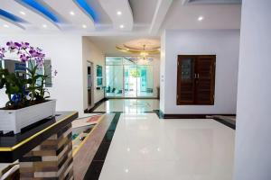 a living room with a potted plant and a hallway at The Linux Garden Hotel (City Amphur Muang Yala) in Yala +250 photos