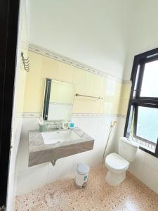 a bathroom with a toilet and a sink at Doi Ngoai Bien Phong SPA Hotel in Buon Ma Thuot