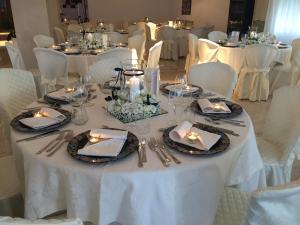 Biały stół z płytami, serwetkami i świecami w obiekcie Albergo Ristorante Cavaliere w mieście Caselle in Pittari +37 zdjęć