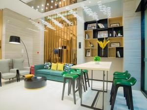 a living room with a couch and a table and chairs at City Comfort Inn Hechi Tian'E Bus Terminal 