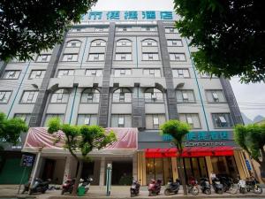 a large building with motorcycles parked in front of it at City Comfort Inn Hechi Tian'E Bus Terminal 