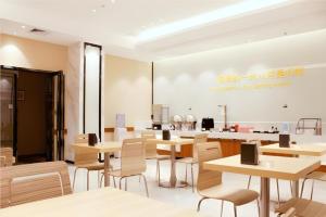a restaurant with tables and chairs and a counter at City Comfort Inn Zhuhai University Town Tangjiawan Plaza in Zhuhai