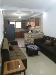 a living room with a couch and a kitchen at الرائد للشقق المفروشة in Amman