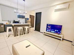 un salon avec une télévision et une cuisine dans l'établissement Urban Suites Georgetown Penang - Affordable & Cozy Stay with High Floor-Sea & Penang Bridge View, à George Town