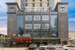 un edificio con auto parcheggiate di fronte di James Joyce Coffetel· Xianyang Renmin Road Central Square Store a Xianyang