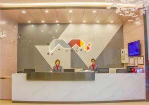 two people sitting at a counter in an office at Borrman Hotel Shaoguan Century East Street Fengcai Building in Shaoguan