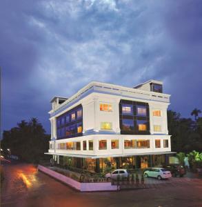 a white building with cars parked in front of it at The Classik Fort in Cochin