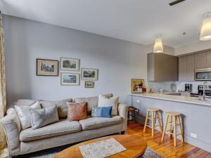 Una sala de estar con un sofá y una cocina. en Above Broughton St 3002, en Savannah